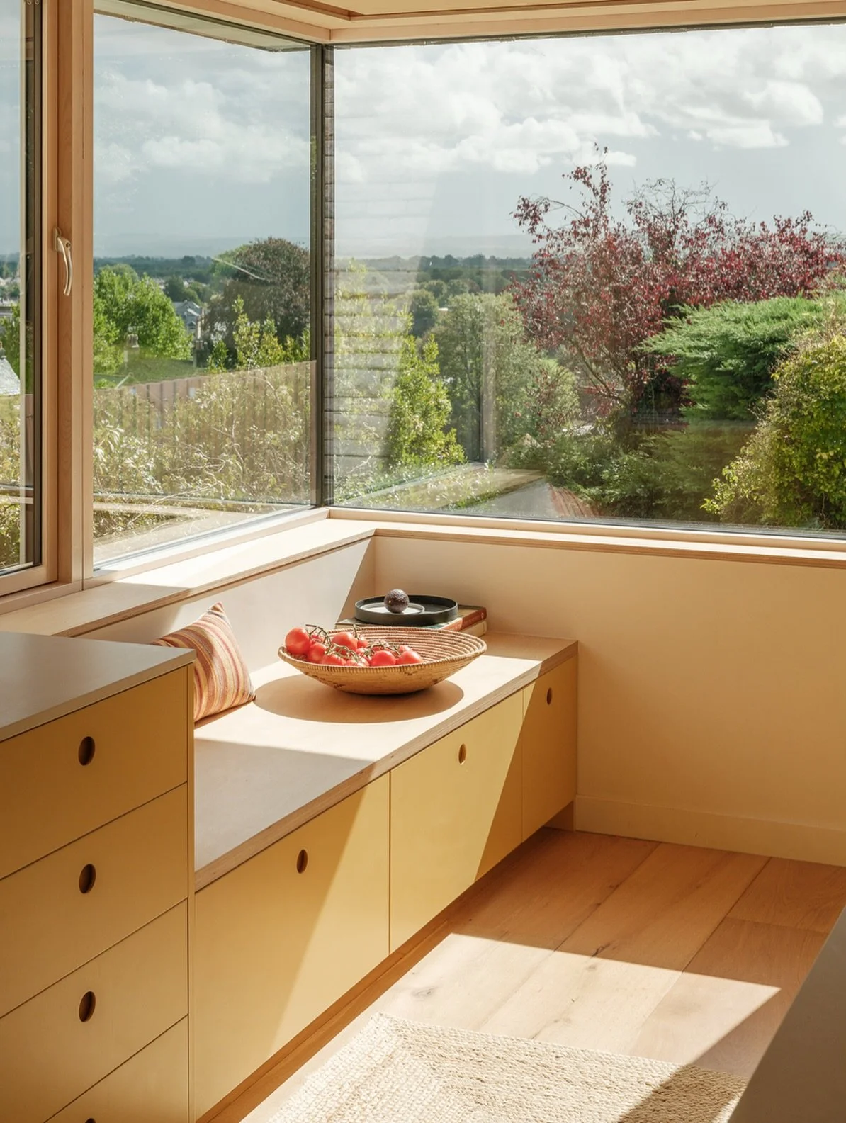 Corner seat at Sky House

A great place to perch whilst cooking socially or enjoying a quiet cup of tea. The corner seat is integrated into the kitchen furniture where the open glass corner captures the wonderful views over the local landscape and dr