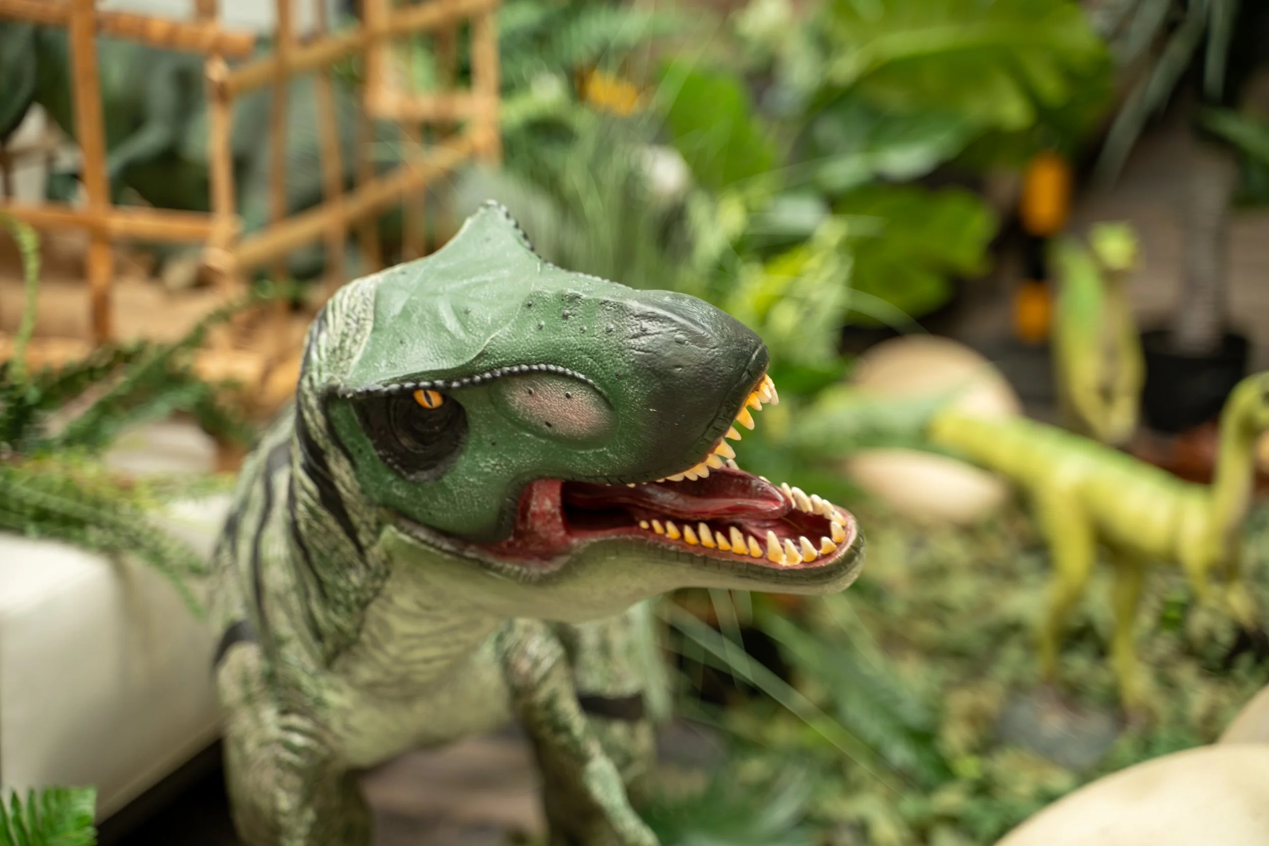 Close-up of a Jurassic Park dinosaur model surrounded by foliage