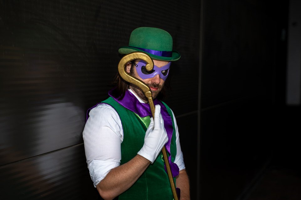 The Riddler cosplayer wearing a green bowler hat and purple mask