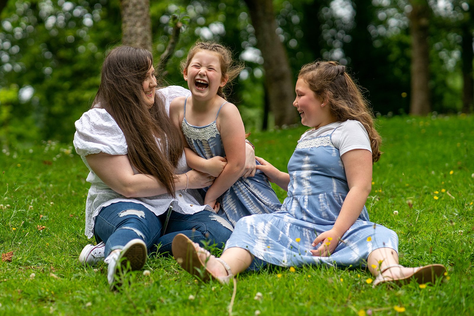 family smiling and laughing together during a portrait session in South Wales