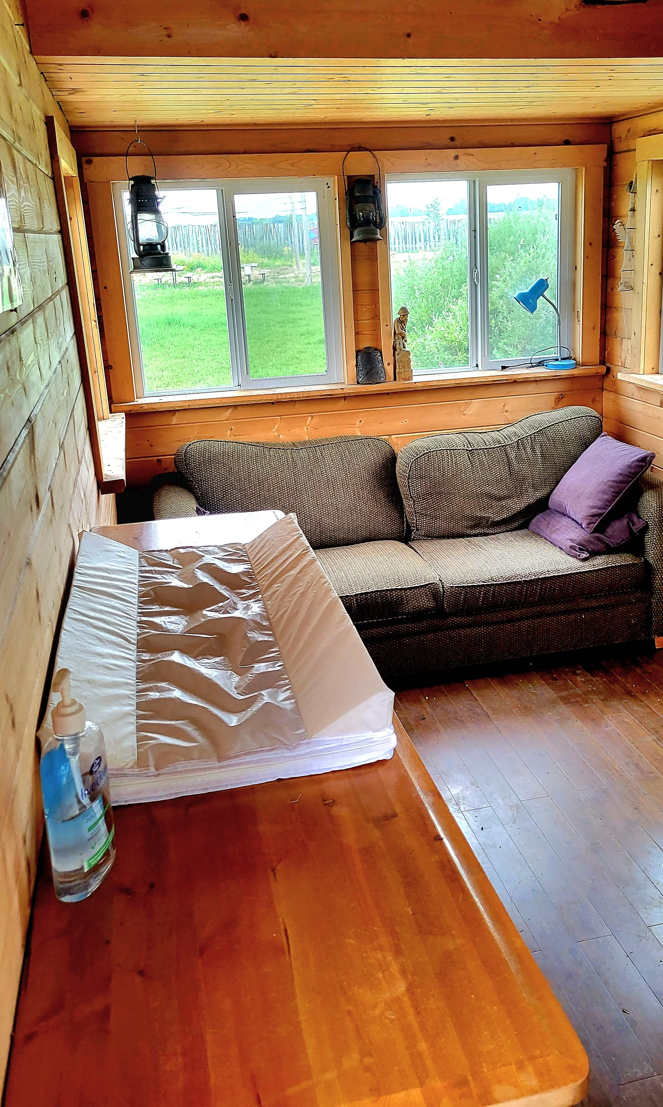 Photo of the inside of the Tiny House with a change table and sofa in frame.