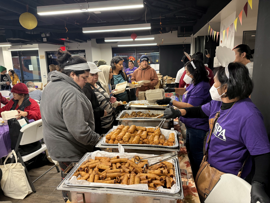 2 women serve hot meals to the community