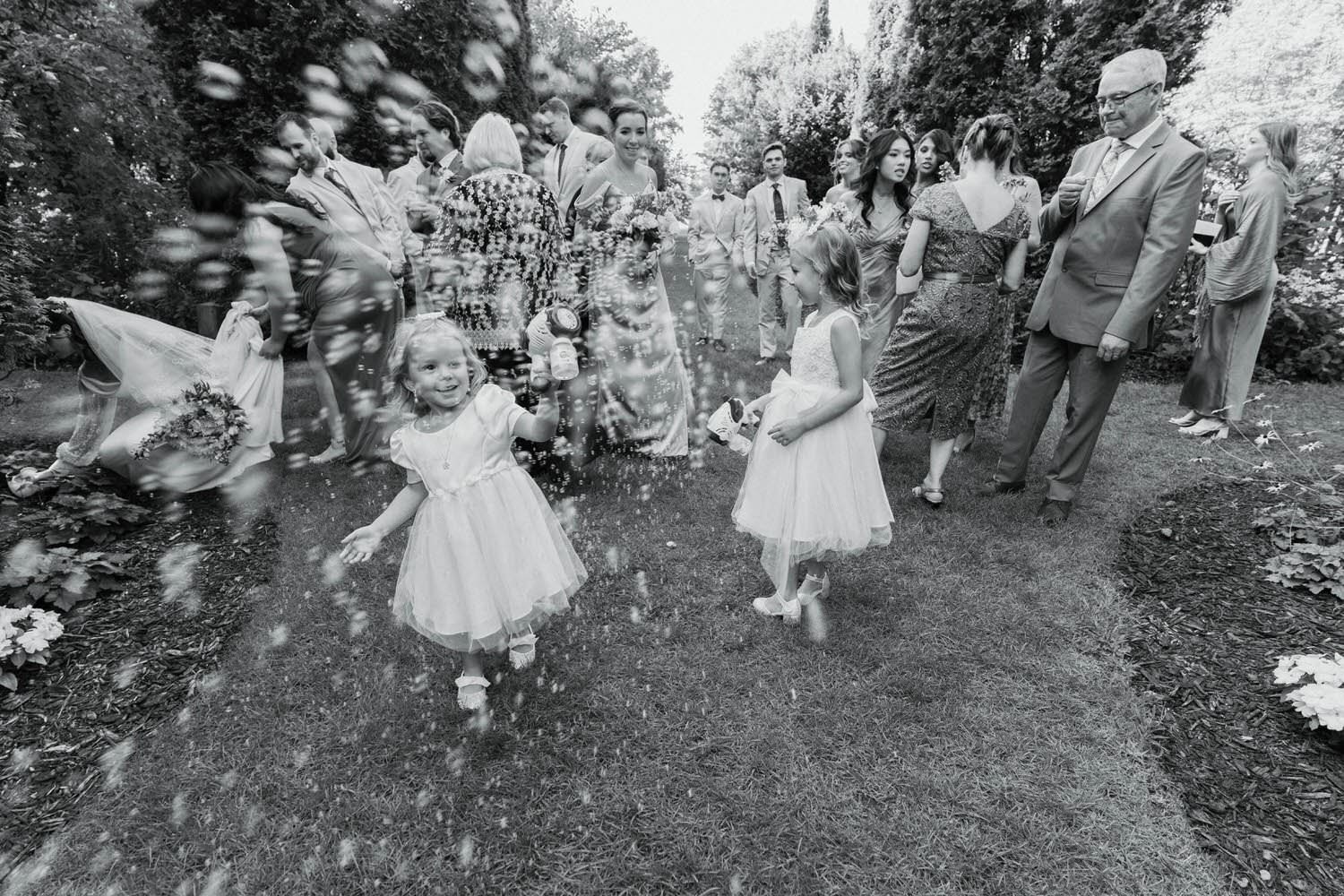 Candid moment of children with bubbles at Cranberry Creek Gardens Ontario wedding by ntario wedding photographer - Amare Studios