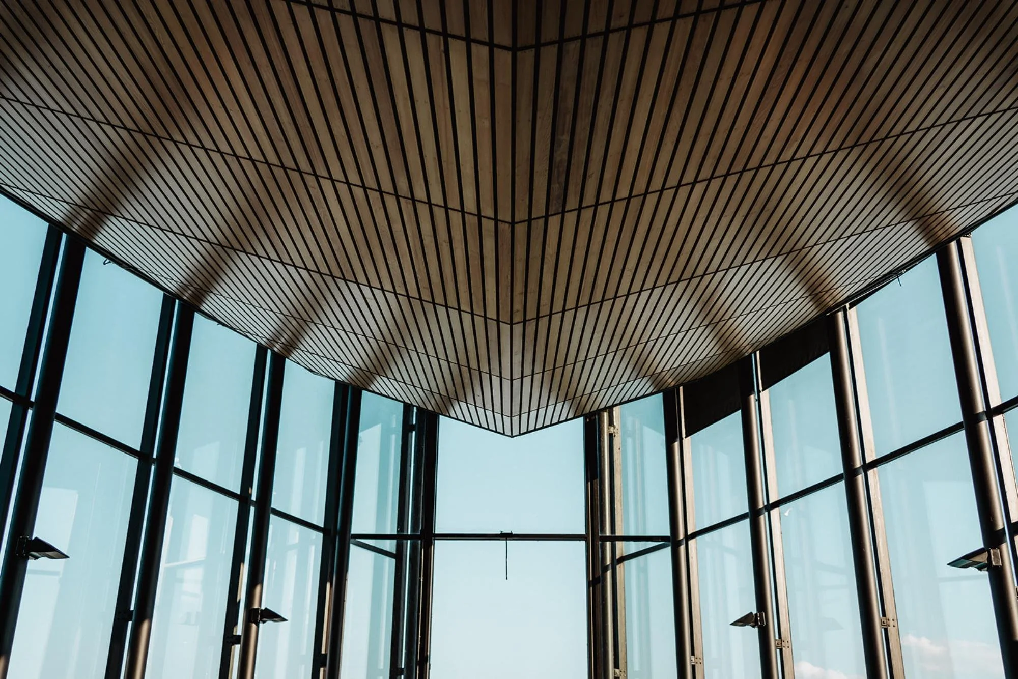 Close-up view of the venue’s wooden slatted ceiling and tall glass windows.