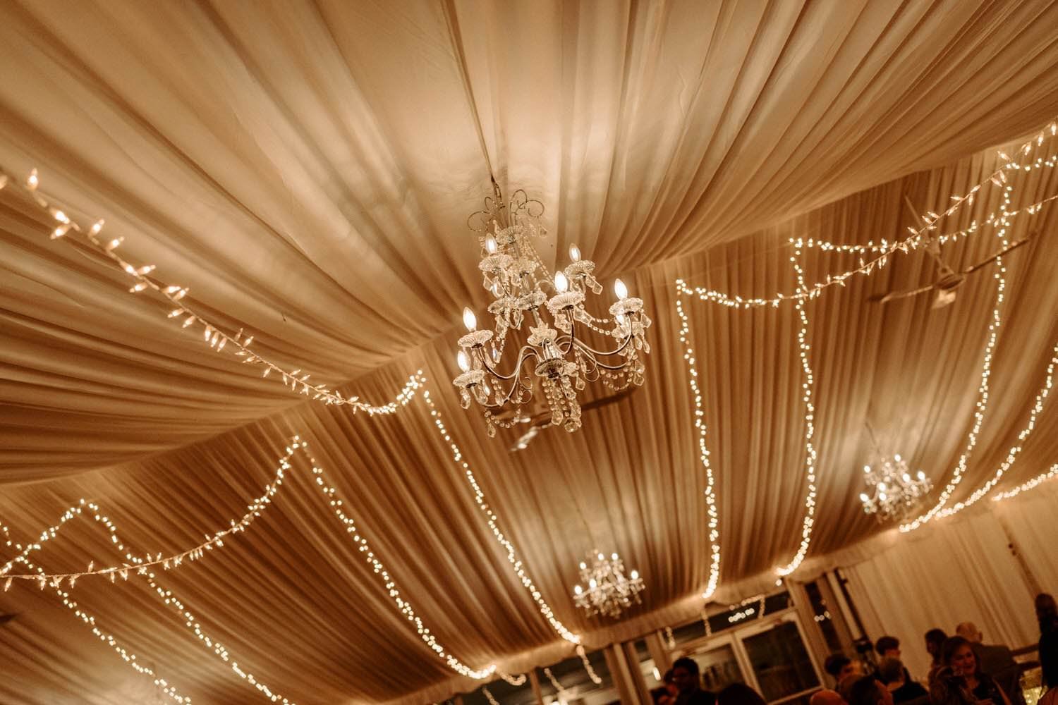Missisauga wedding reception with string lights and chandeliers, photographed by Ontario wedding photographer Amare Studios at Harding Estate