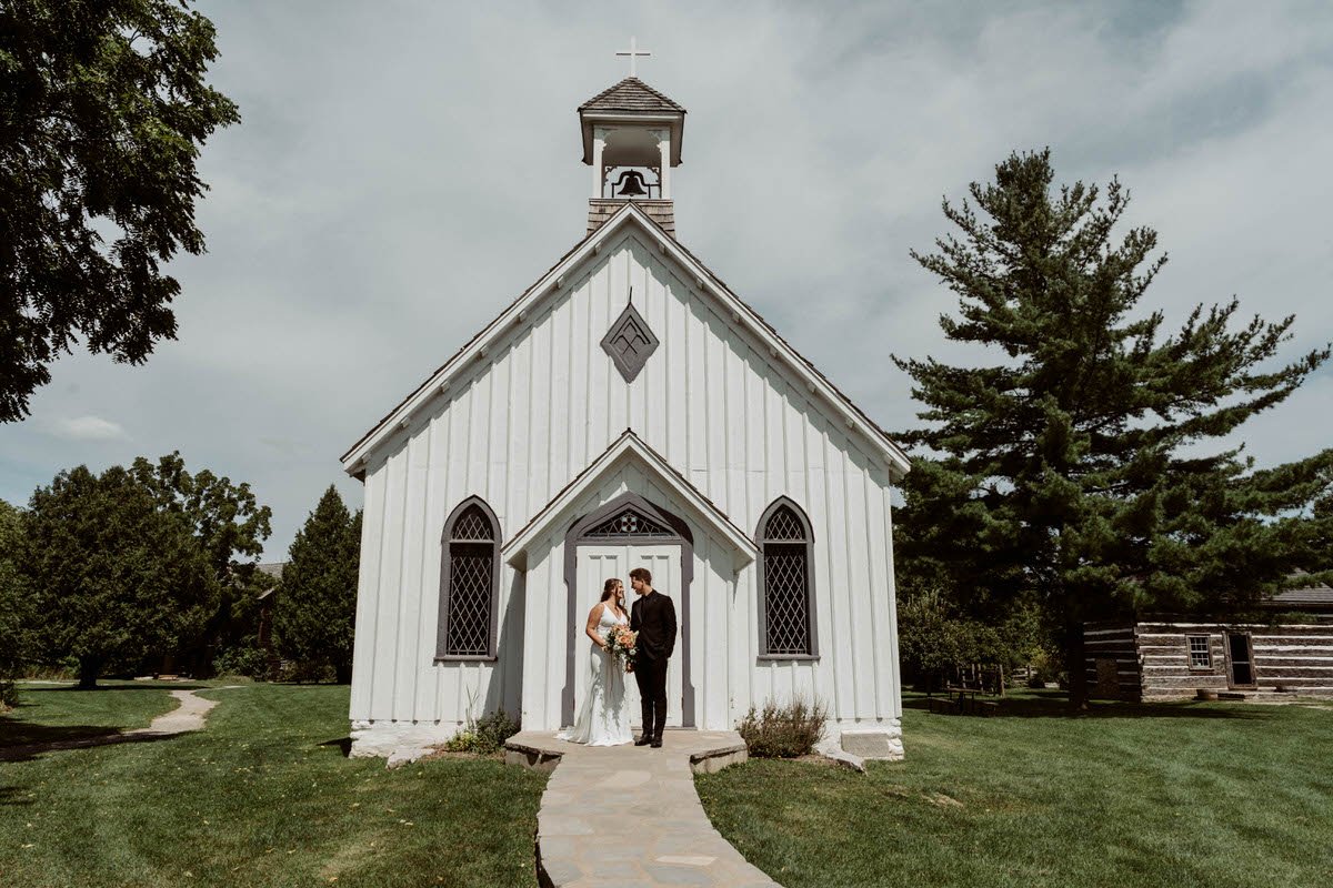 Bride and groom standing in front of the chapel at their Ball's Falls wedding in Lincoln, Ontario