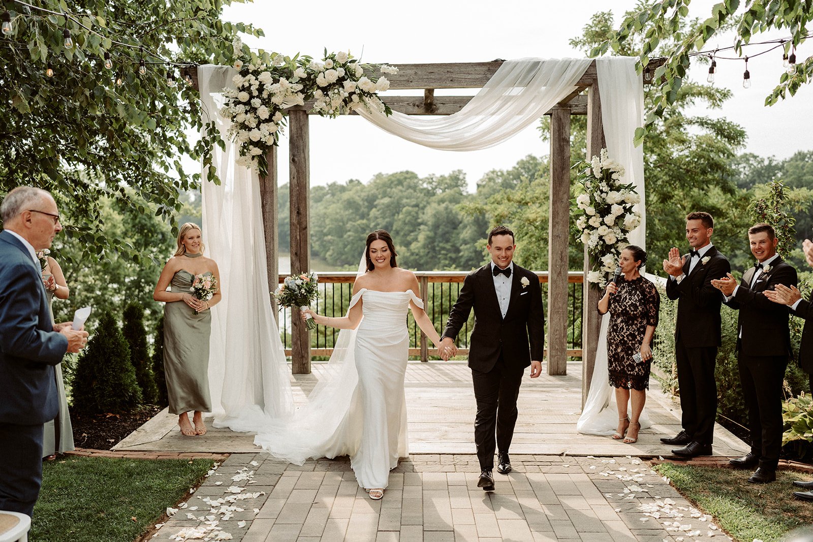 couple exiting the ceremony under the arbour at stonewall estates