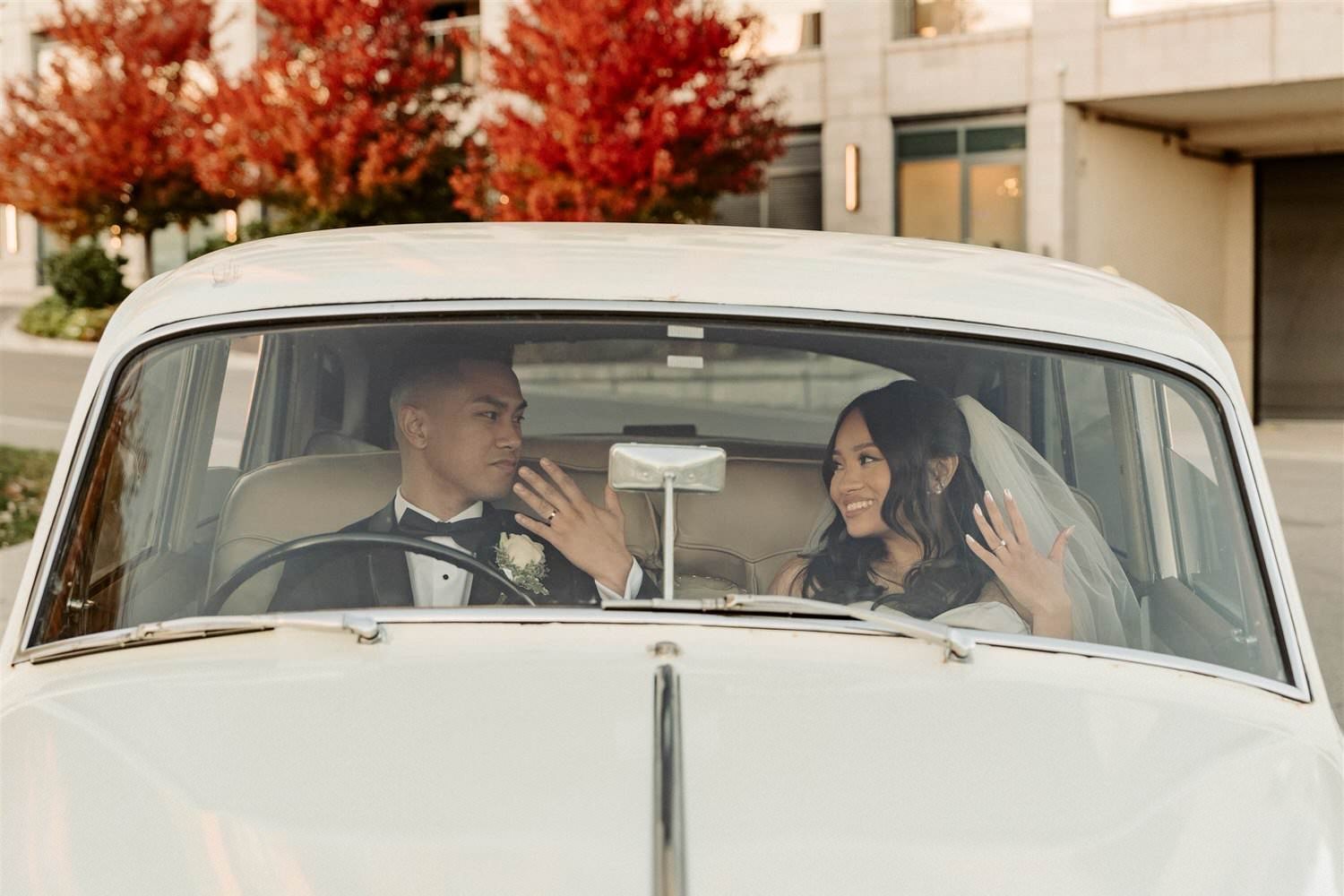 Newlyweds showing wedding rings inside vintage car, Pearle Hotel wedding by Ontario wedding photographer Amare Studios