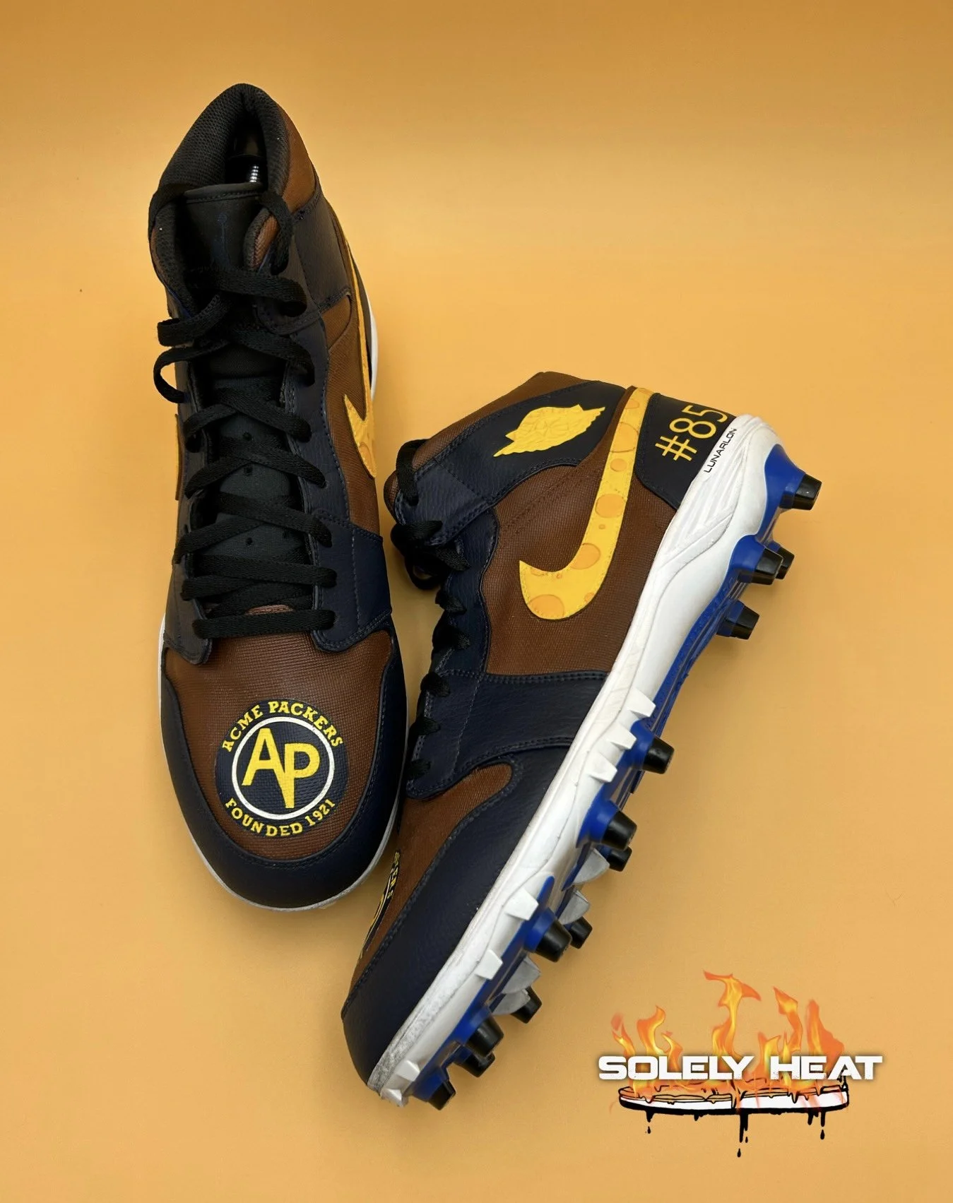 Hand-painted navy, brown and yellow Acme Packers cleats with number 85 detail by Solely Heat