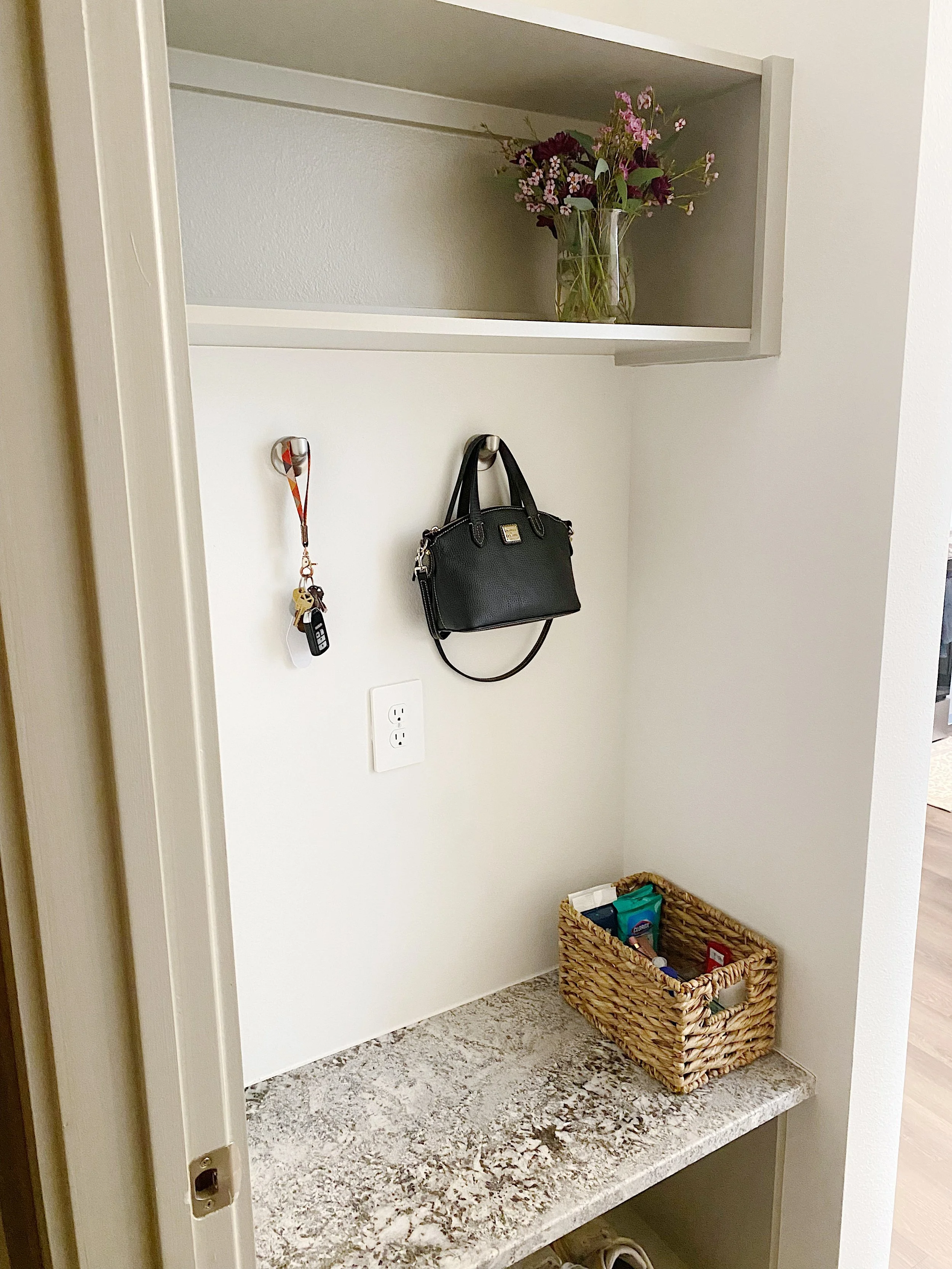 Organized entryway with baskets, hooks, and a bench for everyday essentials by Dallas professional organizer