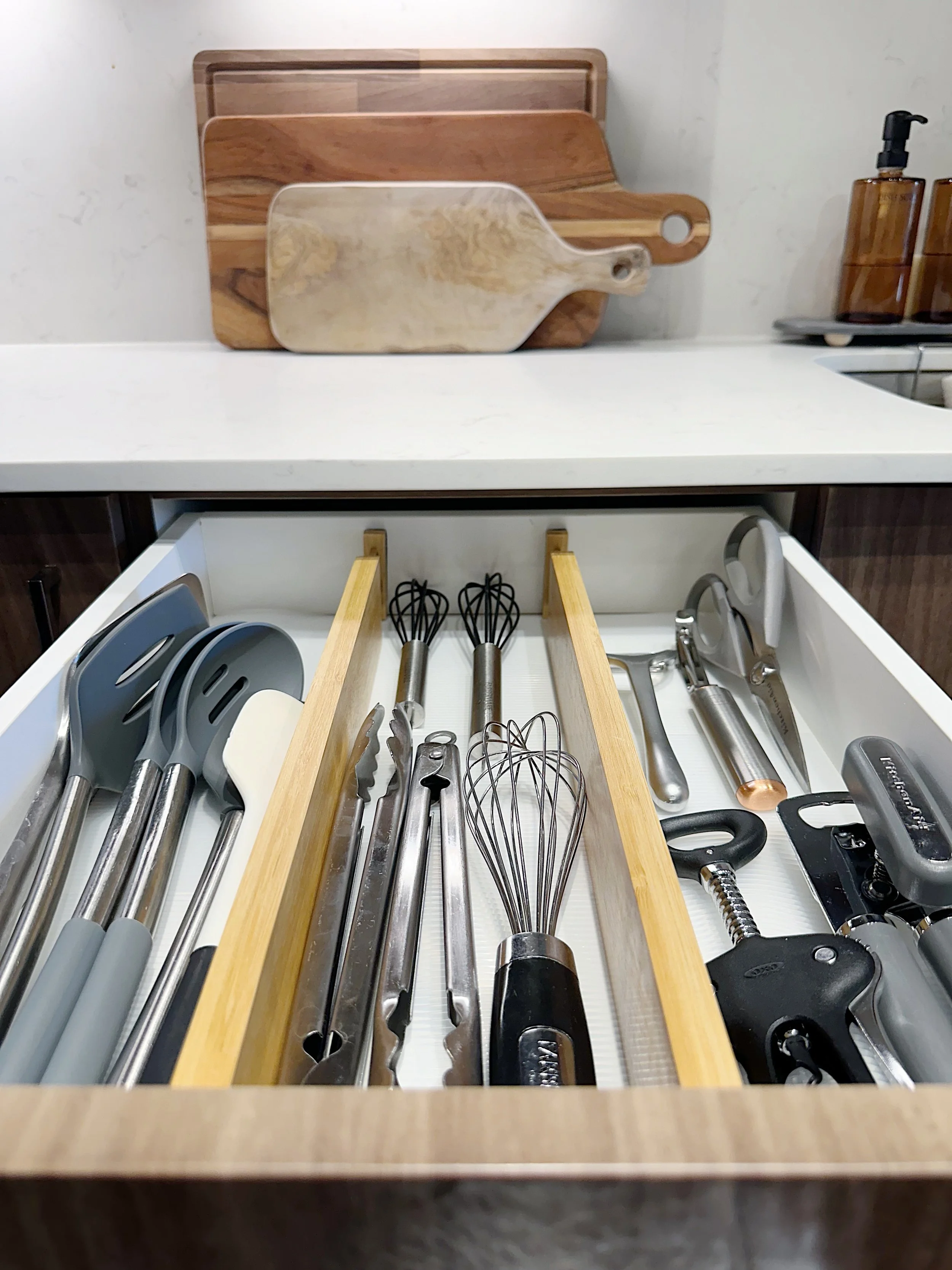 Organized kitchen drawer with bamboo dividers, curated by Dallas professional organizer