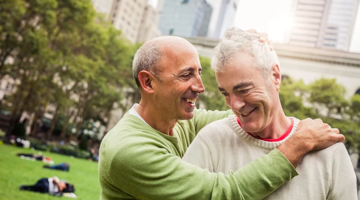 An older gay couple embracing each other..