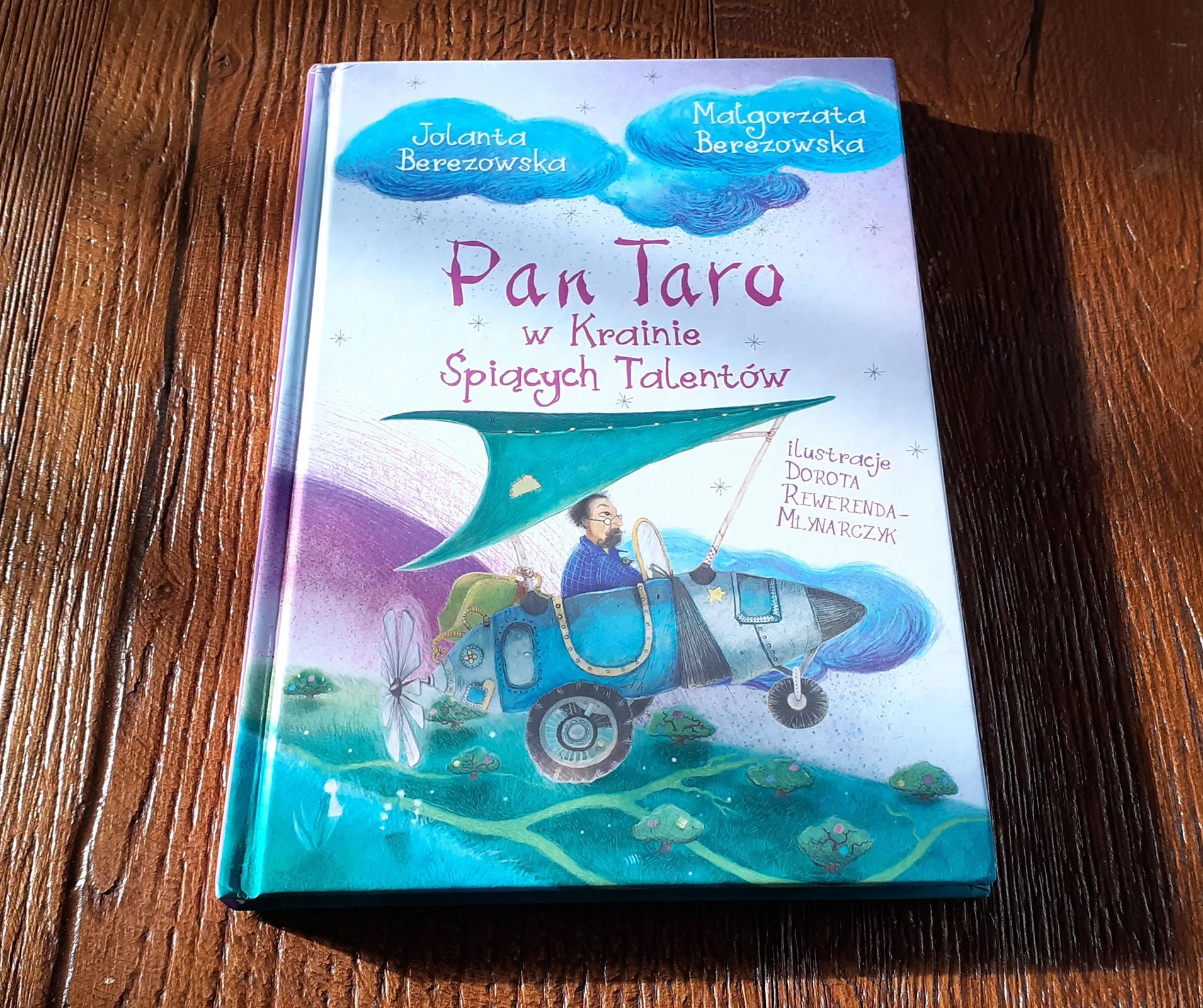 Children's book "Pan Taro w Krainie Śpiących Talentów" on wooden surface