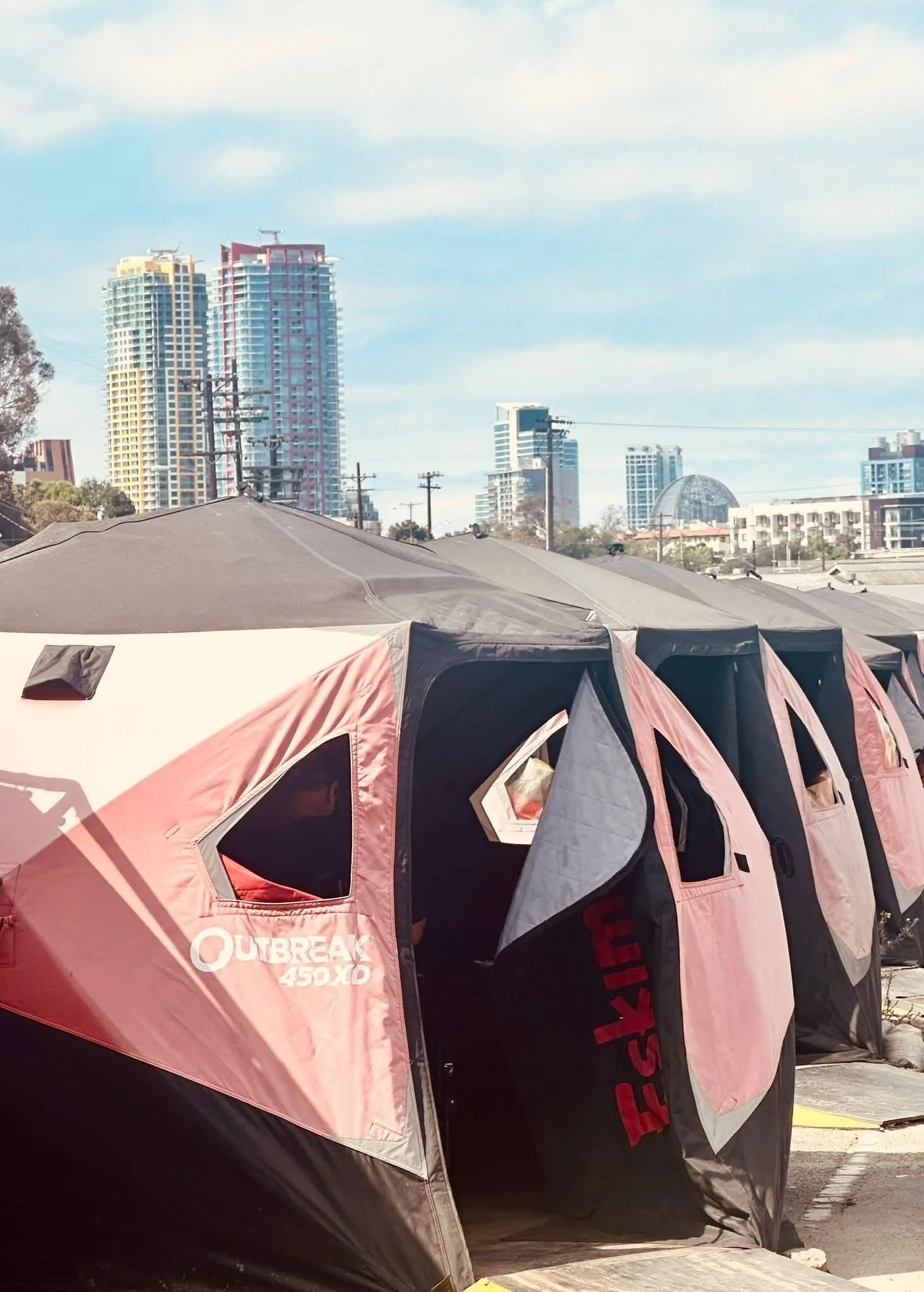 Tents in downtown San Diego with high-rise buildings visible behind them
