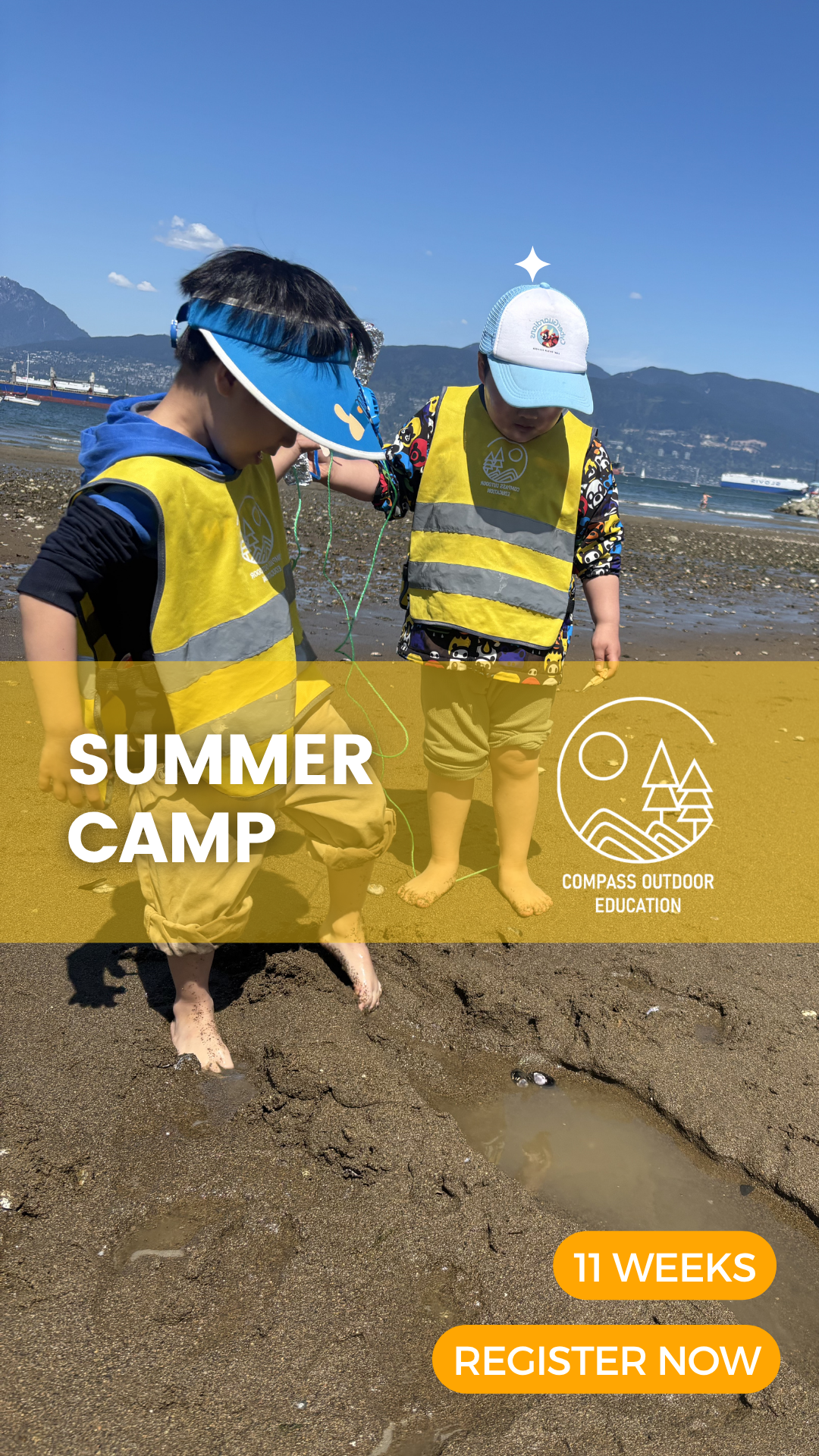Two young children in yellow safety vests exploring the wet sand at a Vancouver beach during Compass Outdoor Education summer camp, with mountains and ocean in the background.