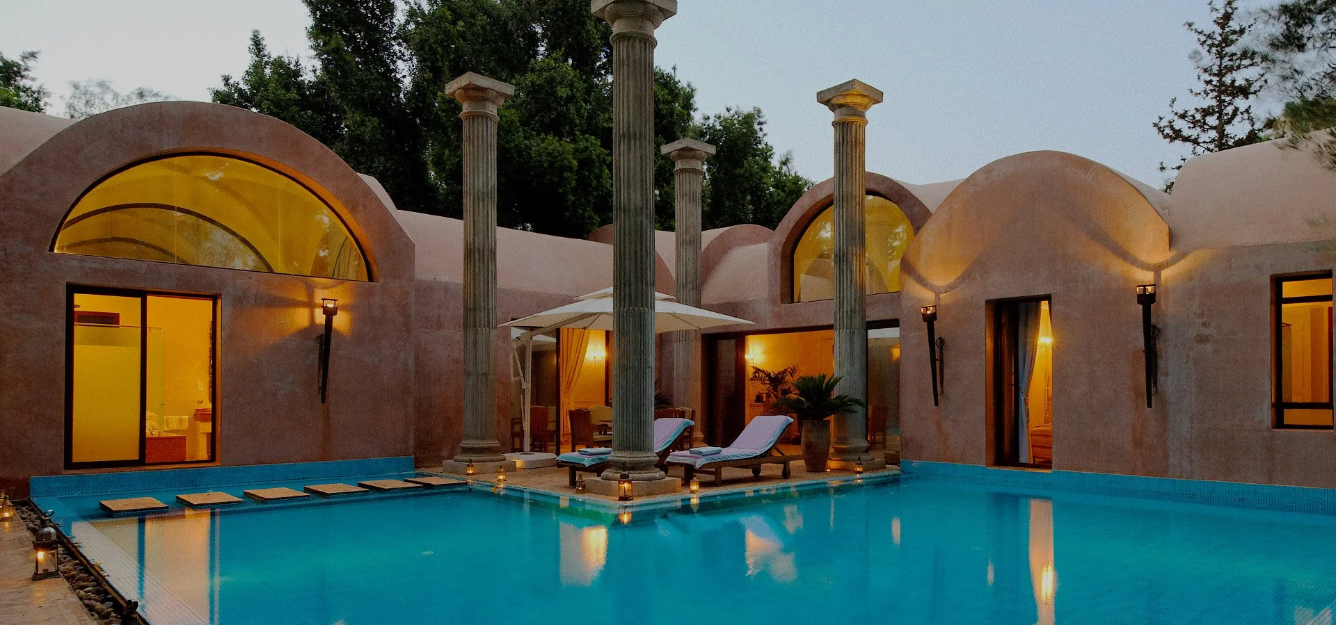 Piscine à l'extérieur avec des colonnes et une maison en style méditerranéen, ambiance nocturne