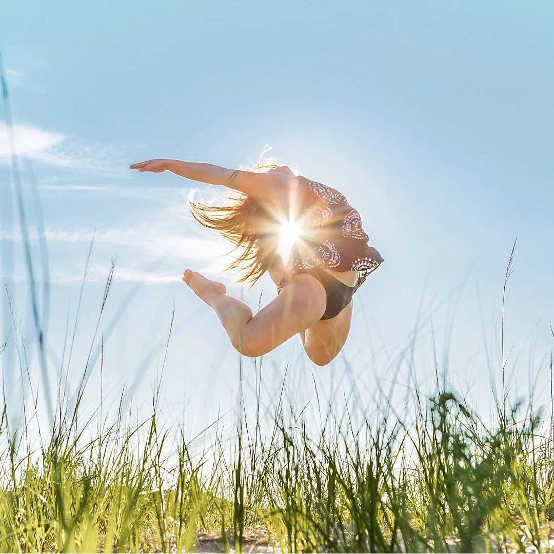 dancer jumping at Lake Michigan with starburst in the background
