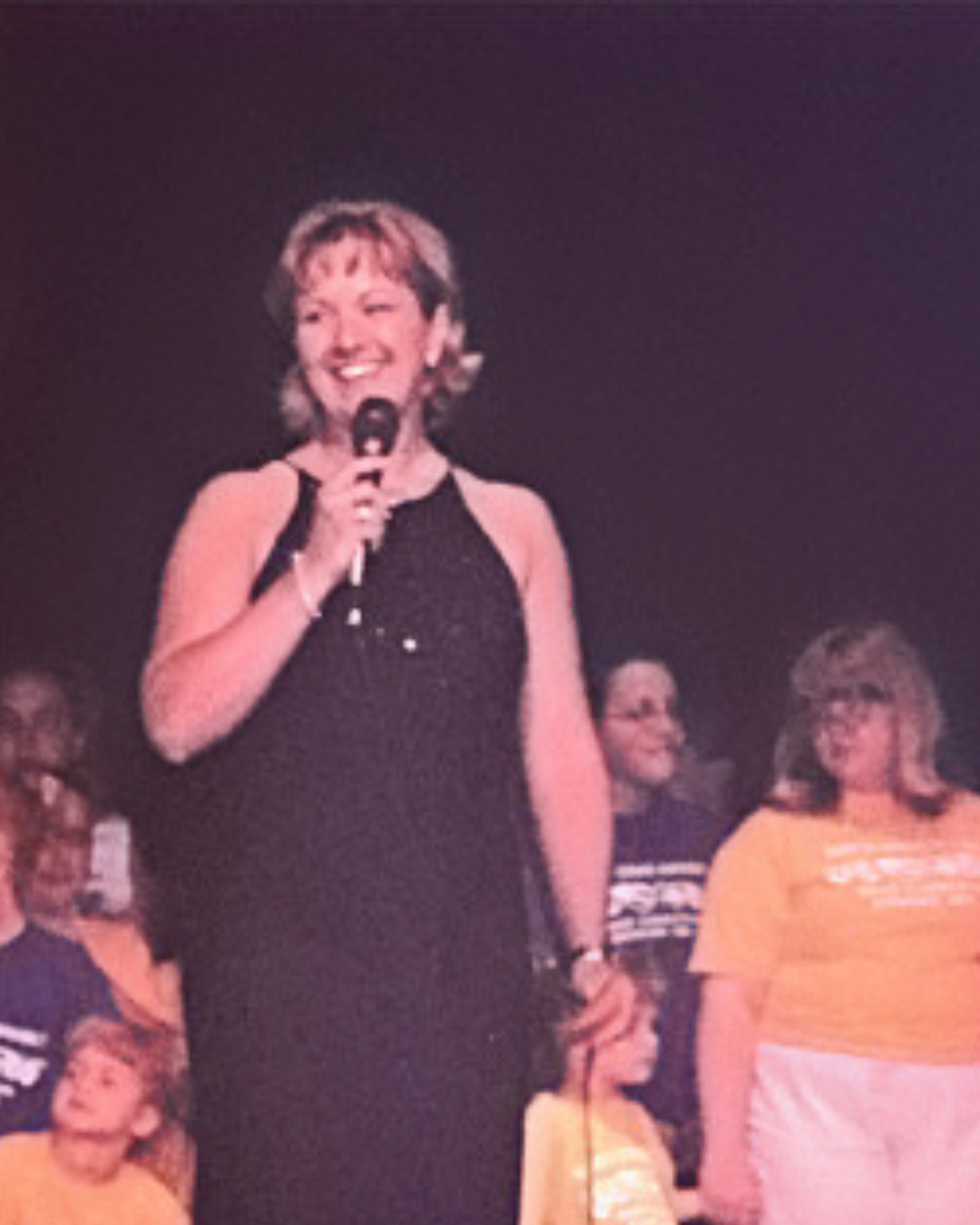 Dance Studio Business Coach Cathy Fitzgerald speaking on stage at recital