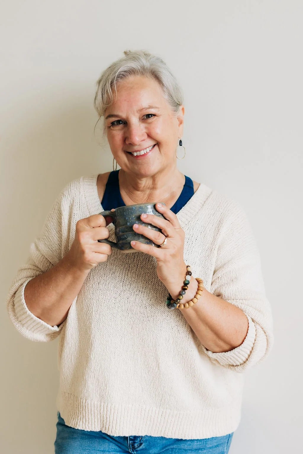 dance Studio Business Coach Cathy Fitzgerald smiling at the camera and holding a blue coffee mug.
