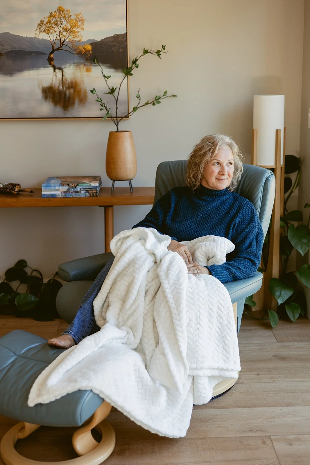 Life coach Cathy fitzgerald sitting in chair with a blanket and looking out the window
