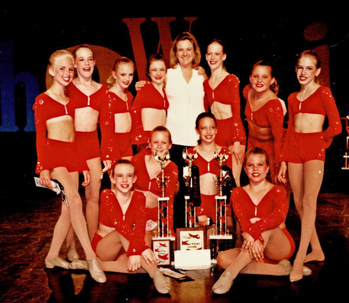 Cathy Fitzgerald with dance students posed with trophies