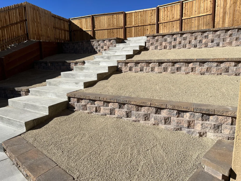 Terraced concrete block retaining walls with steps on a sloped backyard, built by Jefe's Design and Build