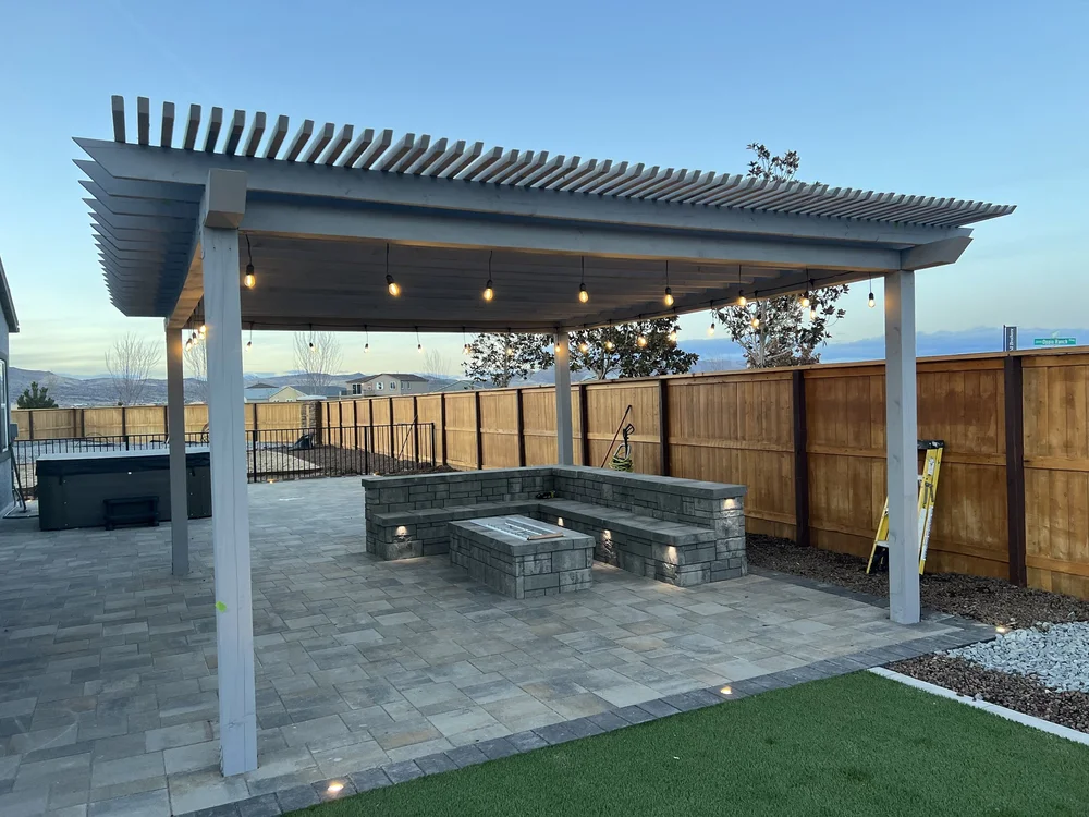 Gray paver patio with a built-in fire pit, seating walls and a modern pergola, built by Jefe's Design and Build