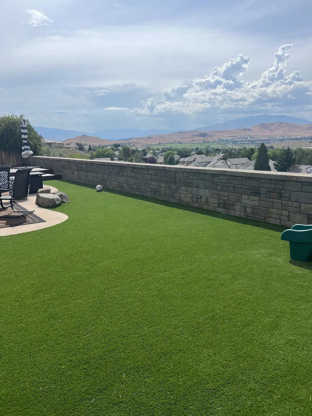Artificial turf lawn with a block wall and a view of the valley and mountains, installed by Jefe's Design and Build