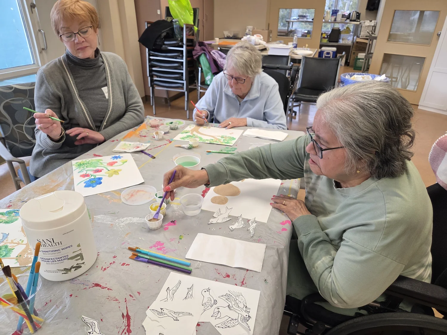 Seniors painting together at a workshop table