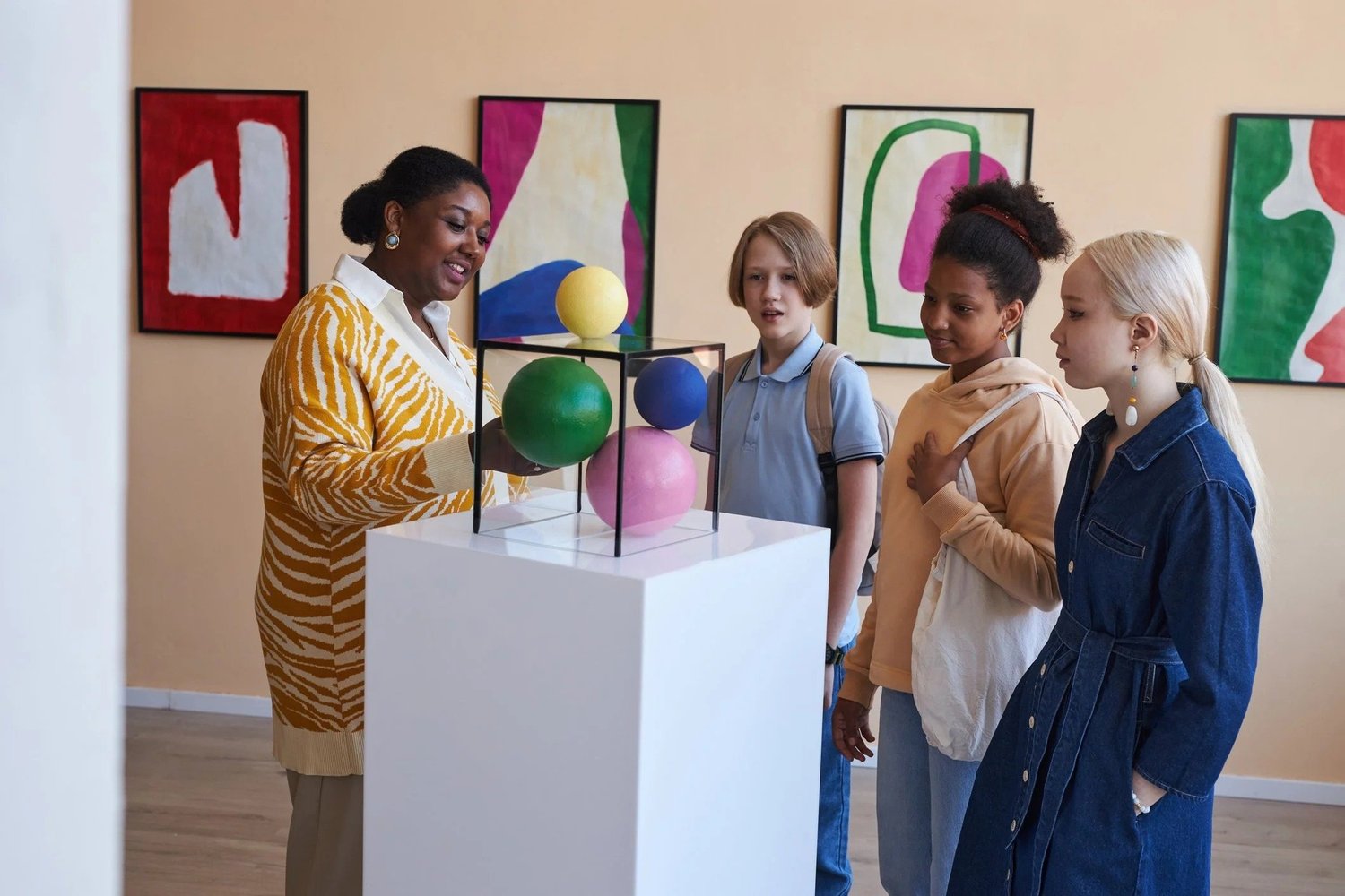 Students on a guided gallery tour looking at a sculpture
