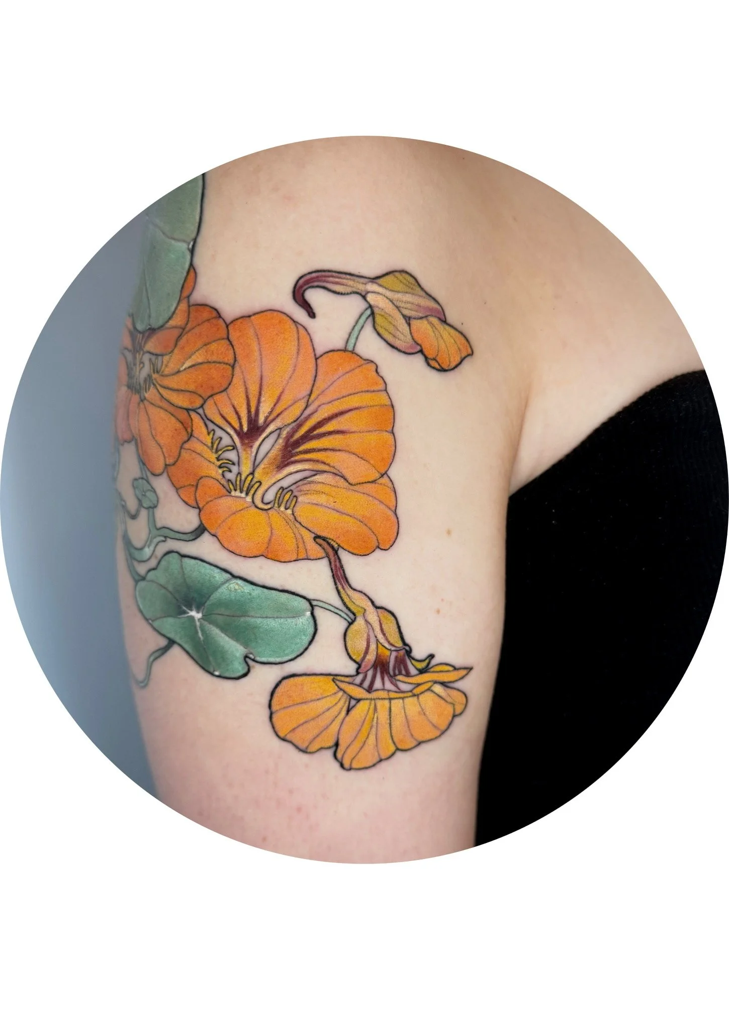 A colorful tattoo of orange flowers with green leaves on a person's upper arm.