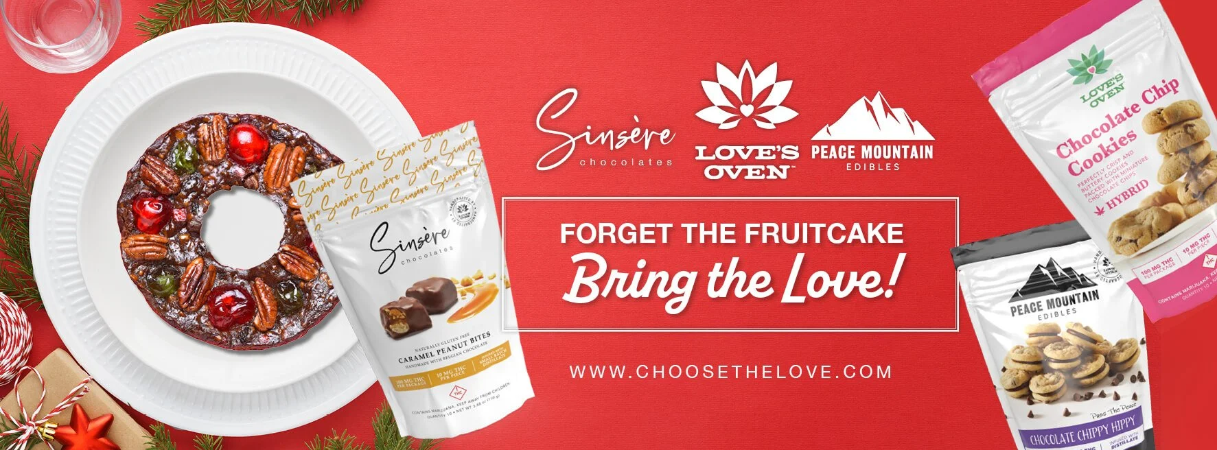 Christmas-themed advertisement for Sen'sire chocolates, Love's Oven, and Peace Mountain Edibles, featuring a decorated fruitcake with nuts and cherries, and packages of chocolates and cookies on a red background.