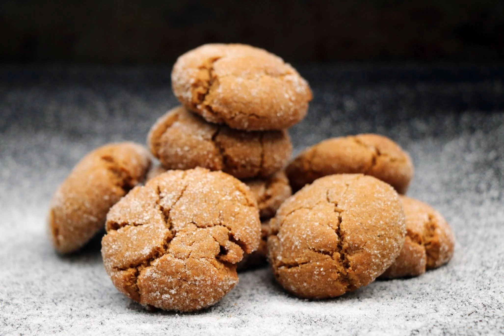 Stack of several ginger cookies on a gray surface with a black background.