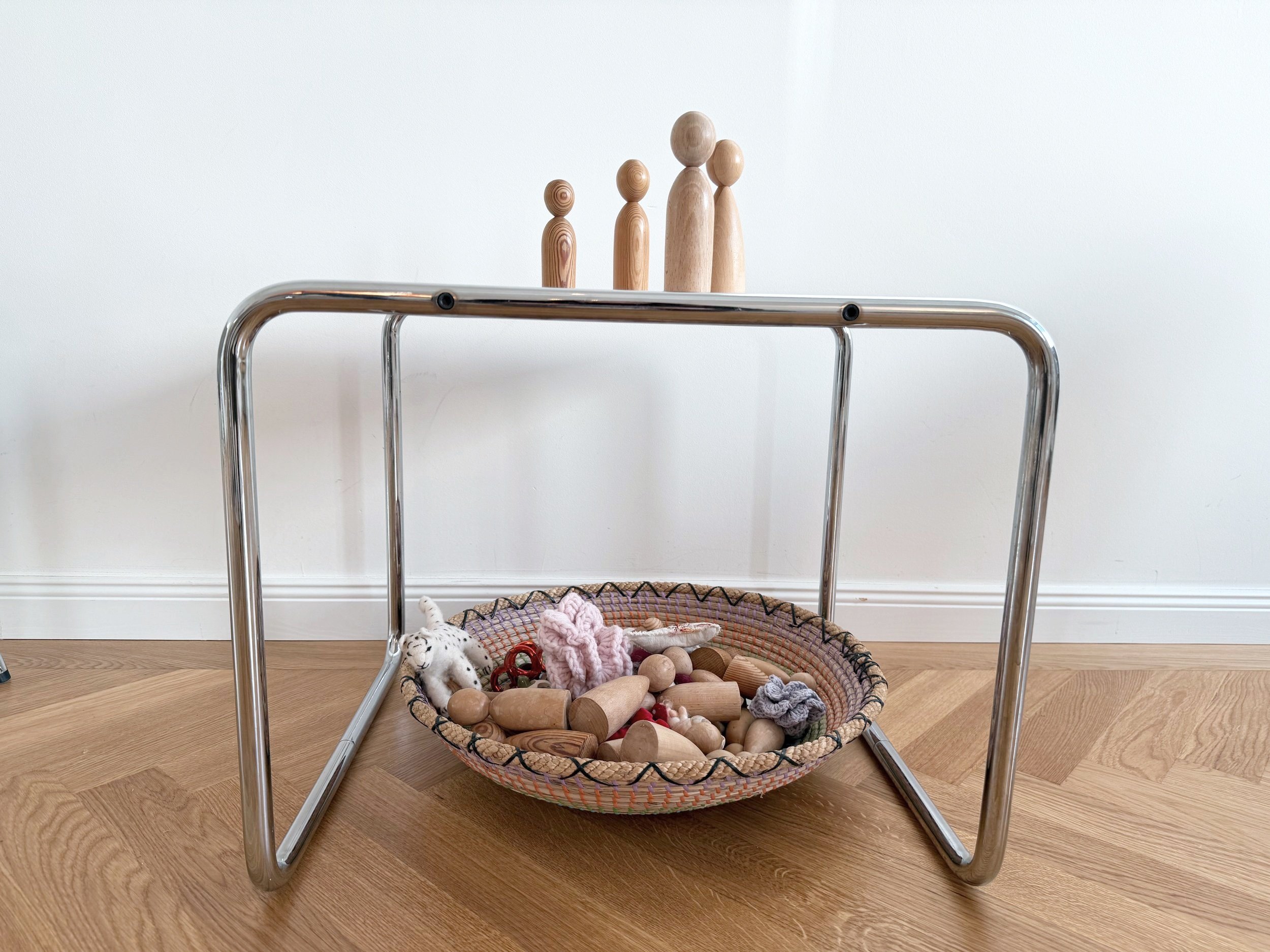 Holzfiguren für Systemische Aufstellungen auf einem Tisch vor weißer Wand
