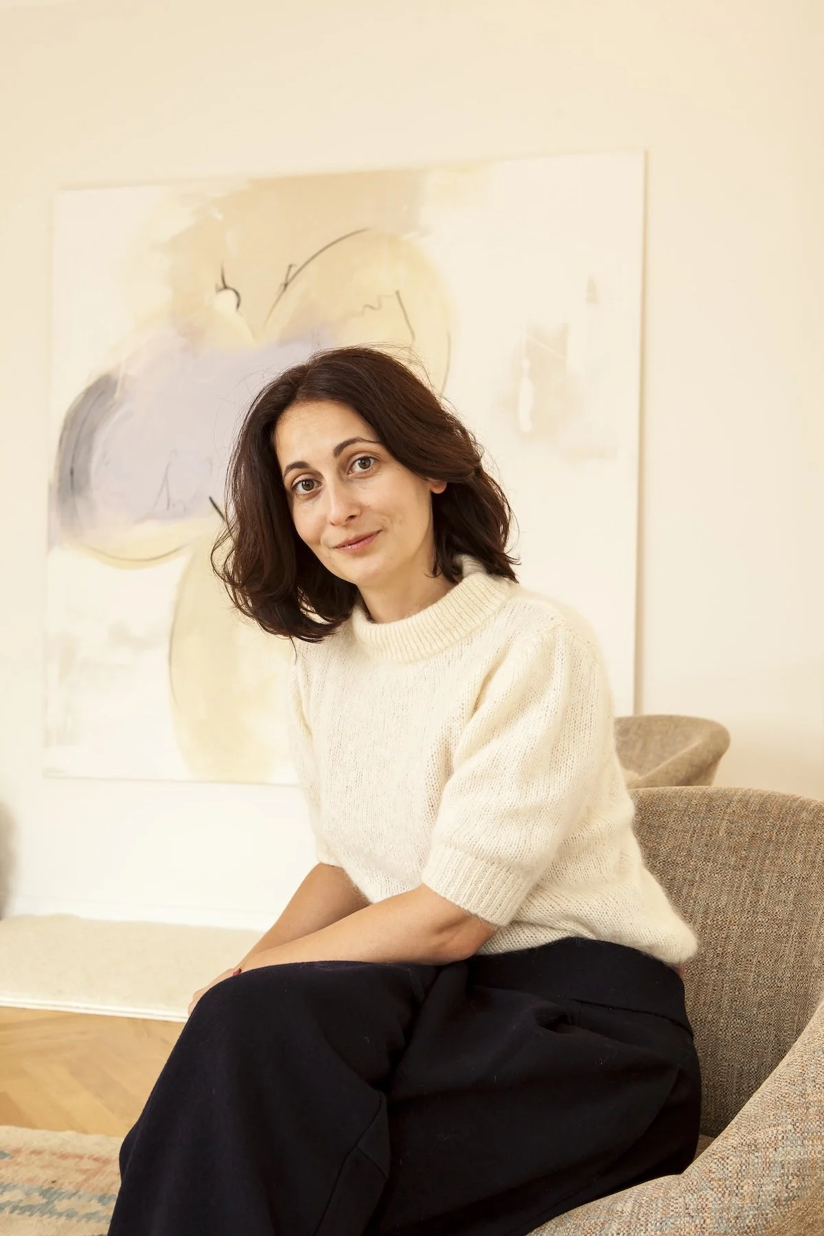 Porträt einer Frau in einem Praxisraum vor einem Kunstwerk