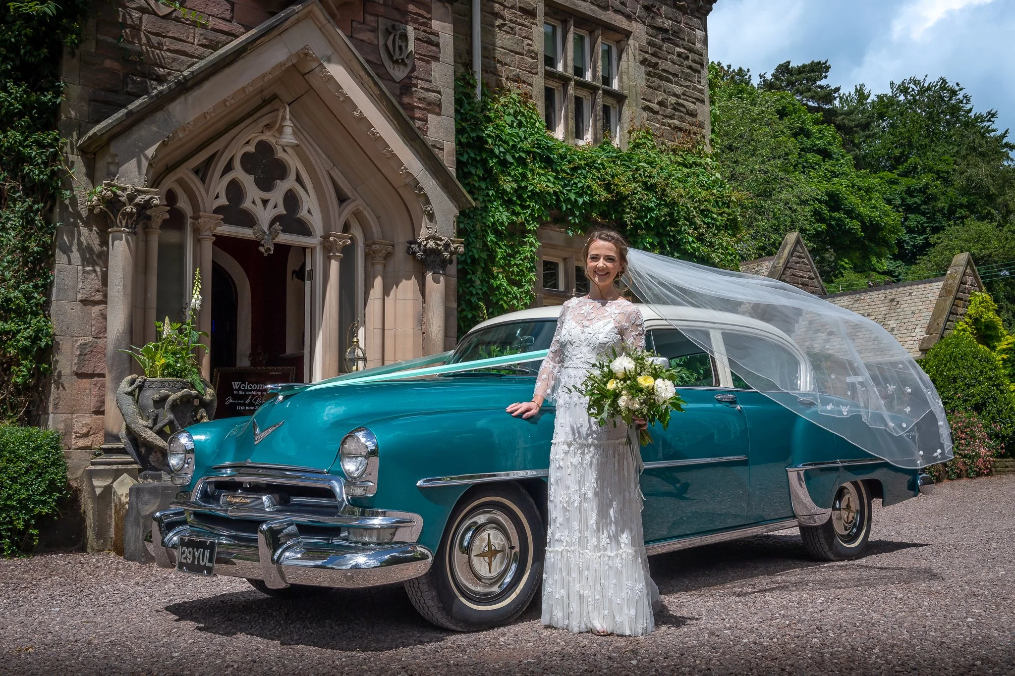 bride posing with vintage wedding car at dunwood hall estate photographed by UK wedding photographer chris peach photography