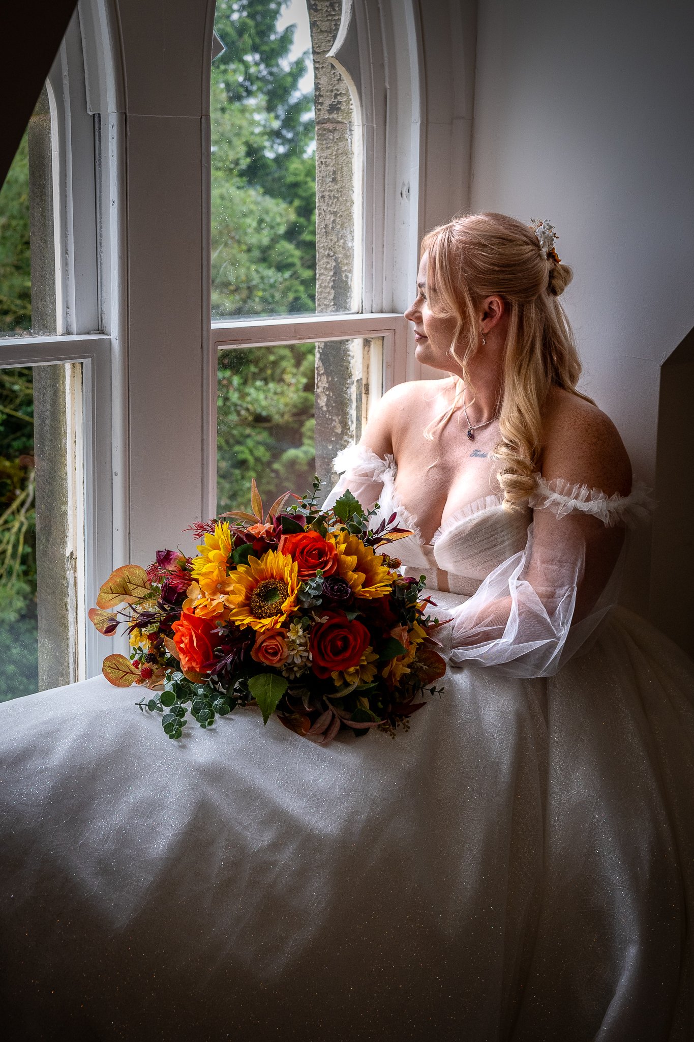 bride looks out the window before her wedding at dunwood hall estate near leek staffordshire photographed by wedding photographer chris peach photography