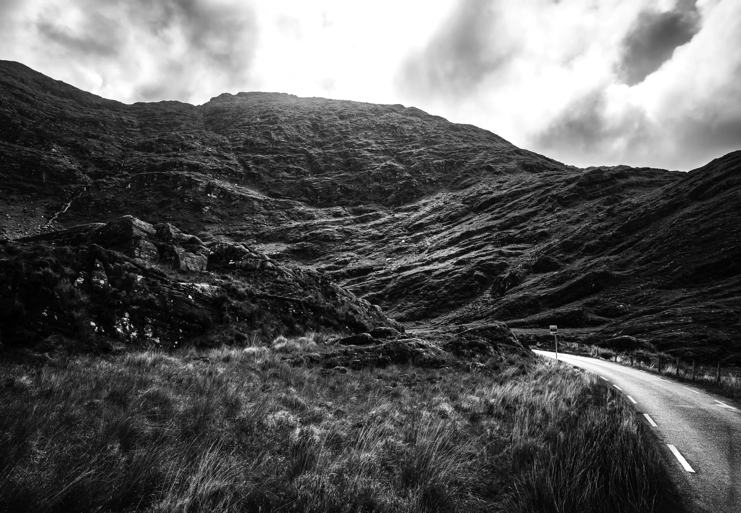   The Bend   / A winding road vanishing into the folds of rugged mountains in Derrynane / Ring of Kerry, 2023   KYI-063