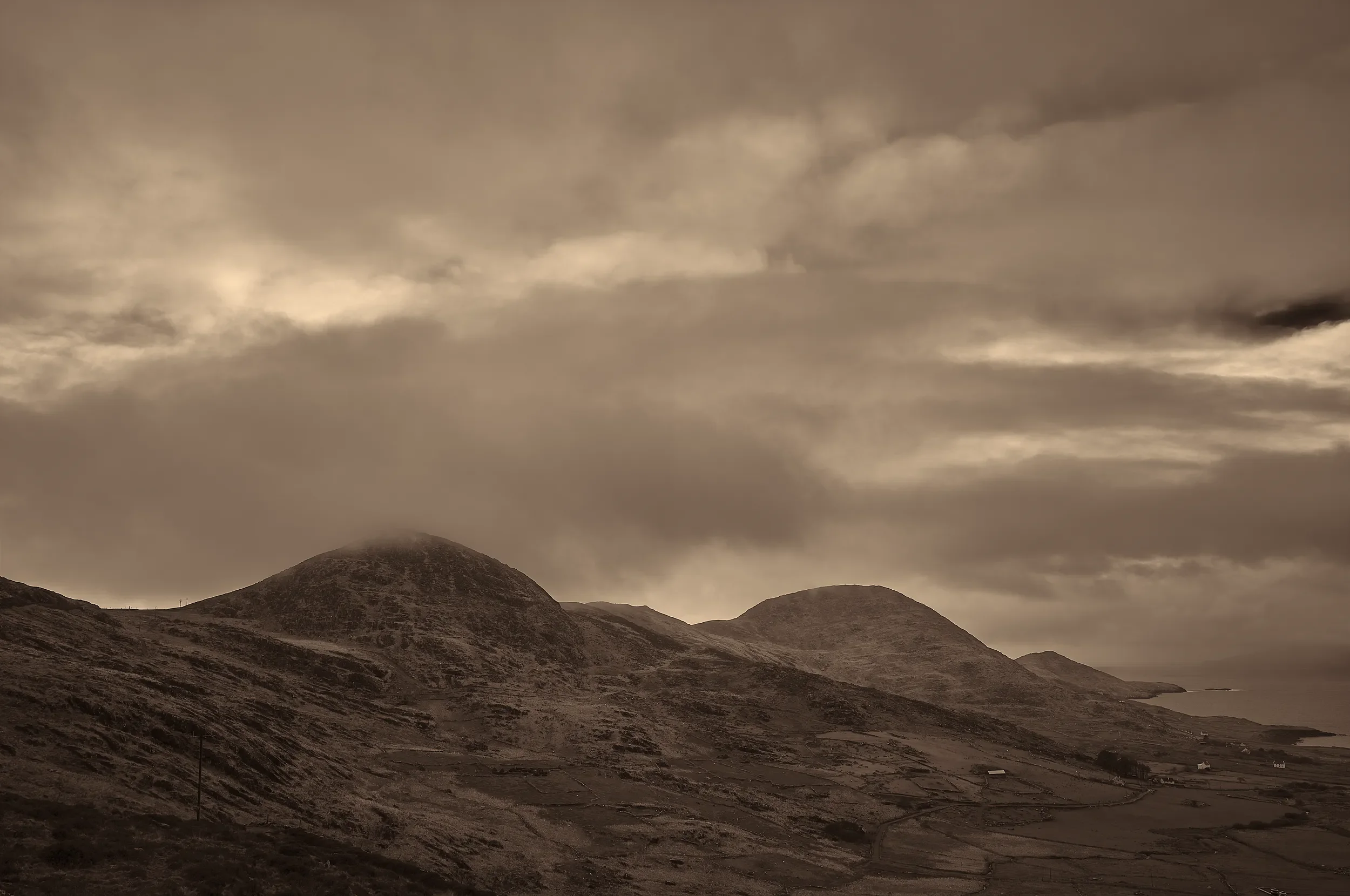   Under Brooding Skies   / Muted light and sweeping clouds over Hogs Head near Waterville / Skellig Ring, 2024   KYI-049