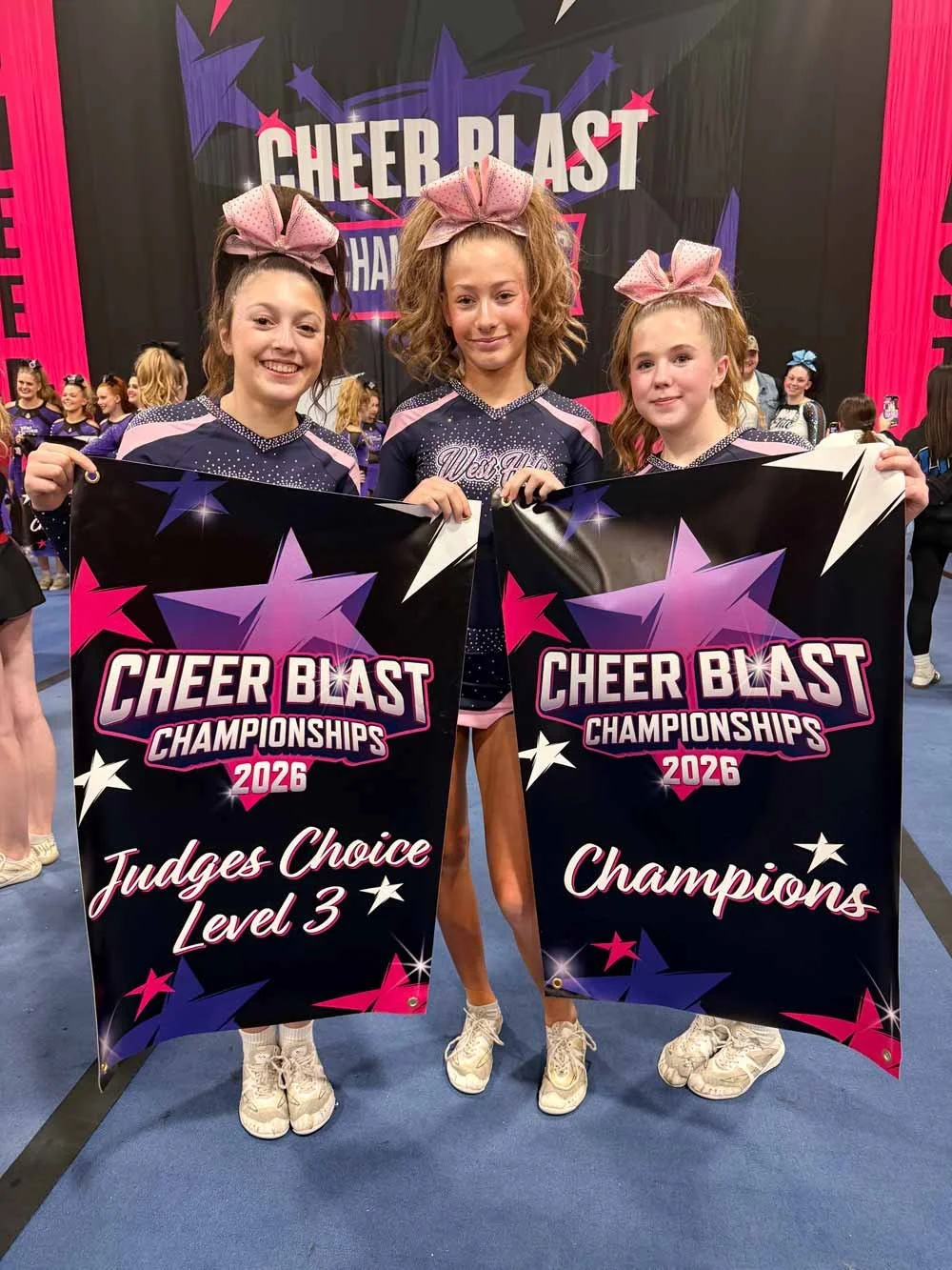 Cheerleaders holding a sign that reads Cheer Blast Champions