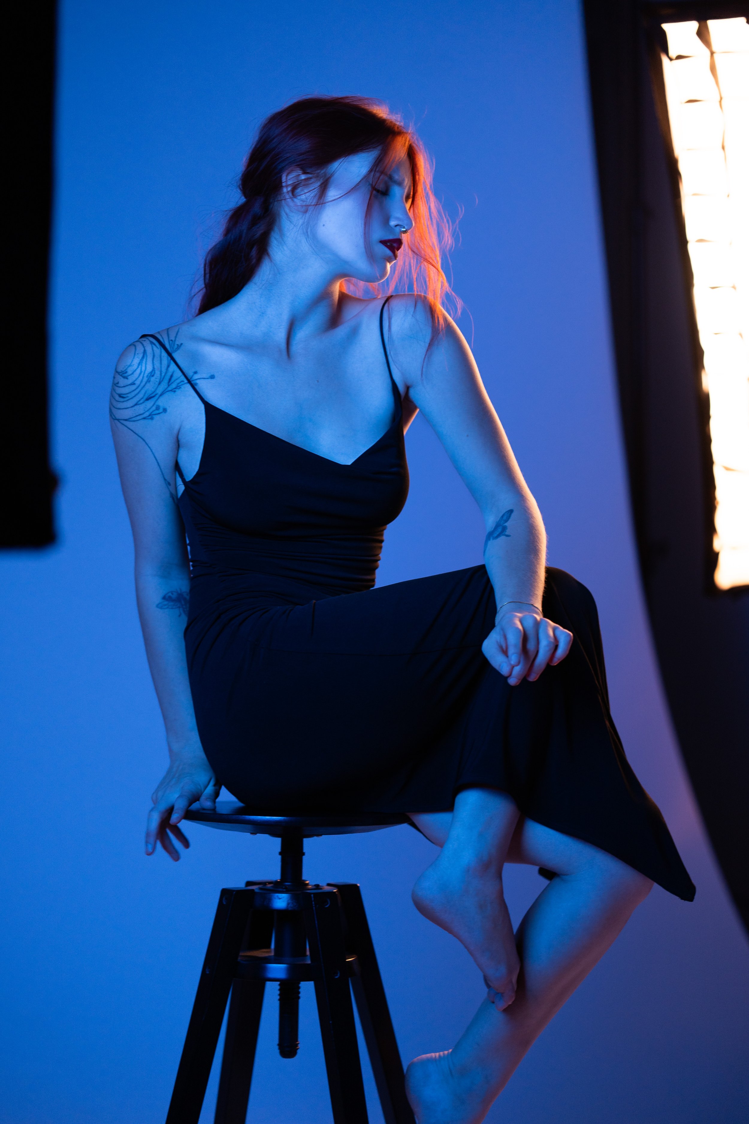 Studio portrait of a red head women posing in a bleu tone