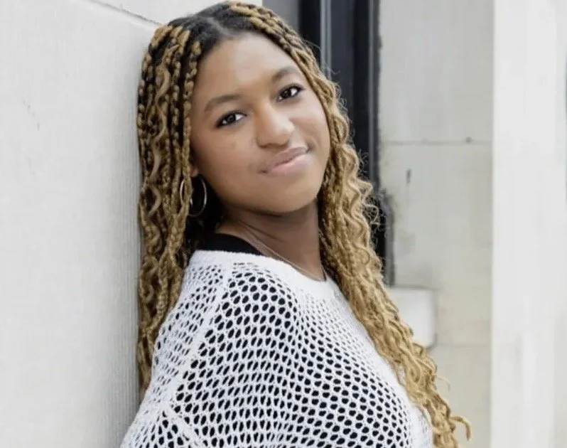 a girl with blonde hair smiling.