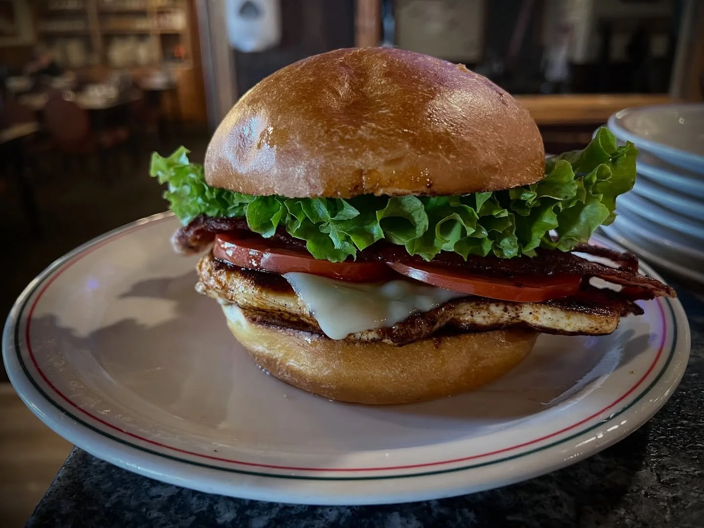 Tuesday’s Special: our Chicken Club Sandwich — seasoned grilled chicken layered with Swiss cheese, crispy bacon, fresh avocado, lettuce, and tomato on a toasted bun. 🥑🍅
