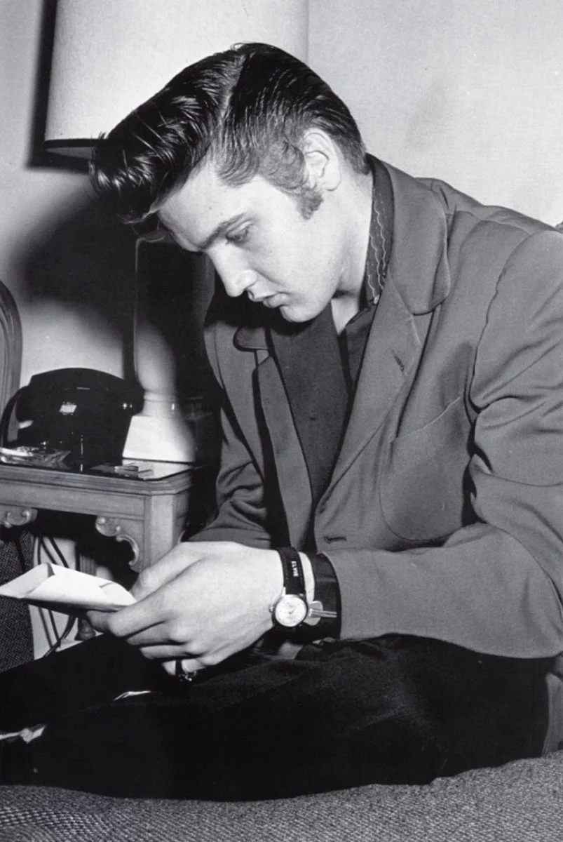 Elvis looking at a letter