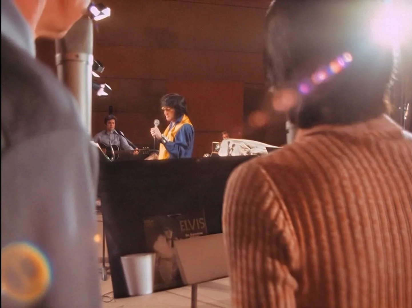 Elvis Presley singing into a microphone during rehearsals.