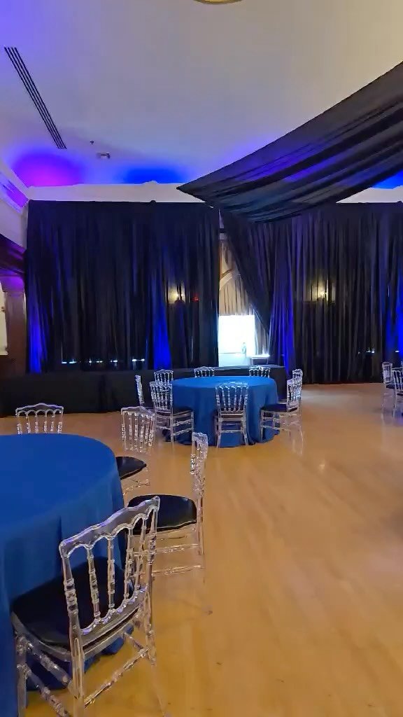 Event at Centro Asturiano with our Black & Blue Draped Ceiling “Starburst” & Wall Draping, Clear Napoleon Chairs, & Blue Up Lighting. —————————————&