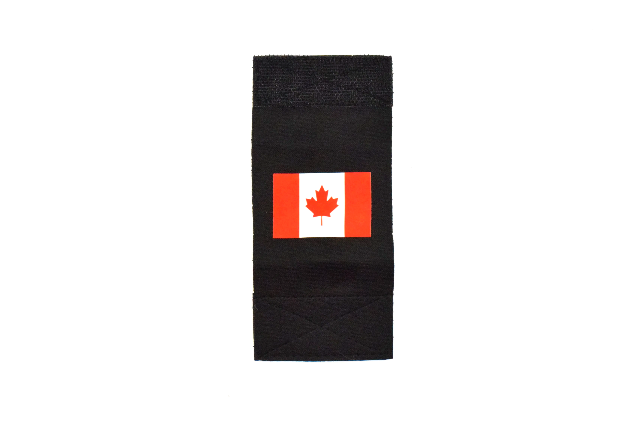 A black object, possibly a wallet or passport holder, with a small Canadian flag sticker on it, featuring a red maple leaf in the center.