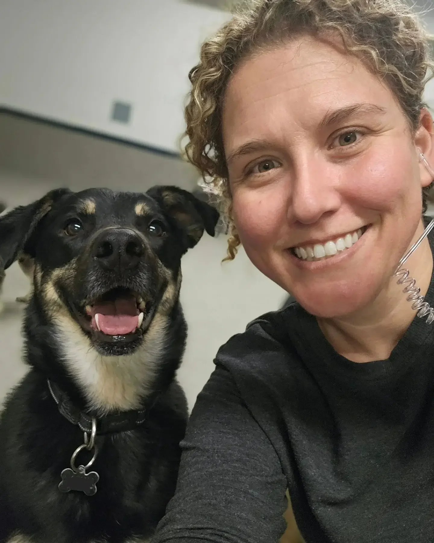 Nikki Nordick the owner of Airdrie Puppy Pals takes a selfie with her happy black and tan dog, both smiling at the camera in Airdrie Alberta