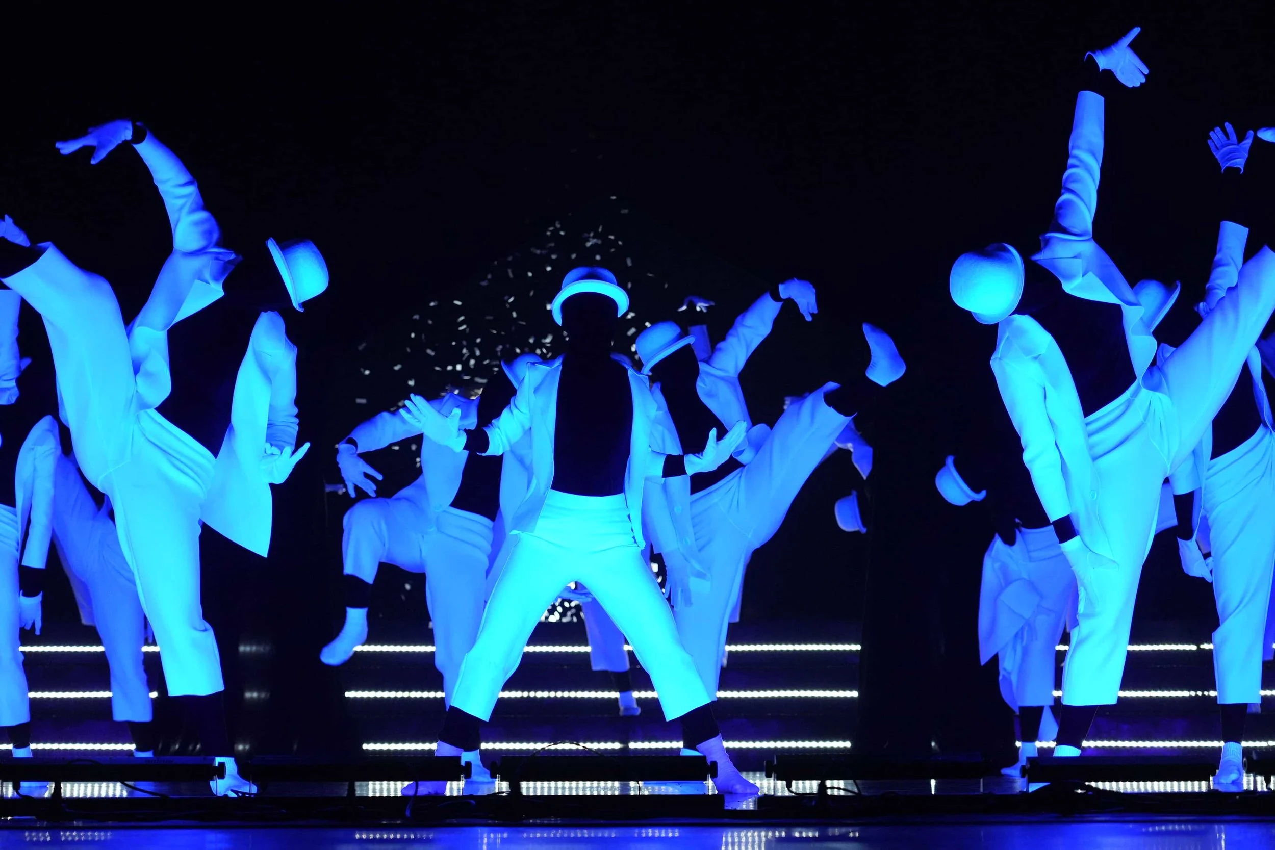 Live hip-hop dance performance captured under dramatic theatrical and stage lighting.