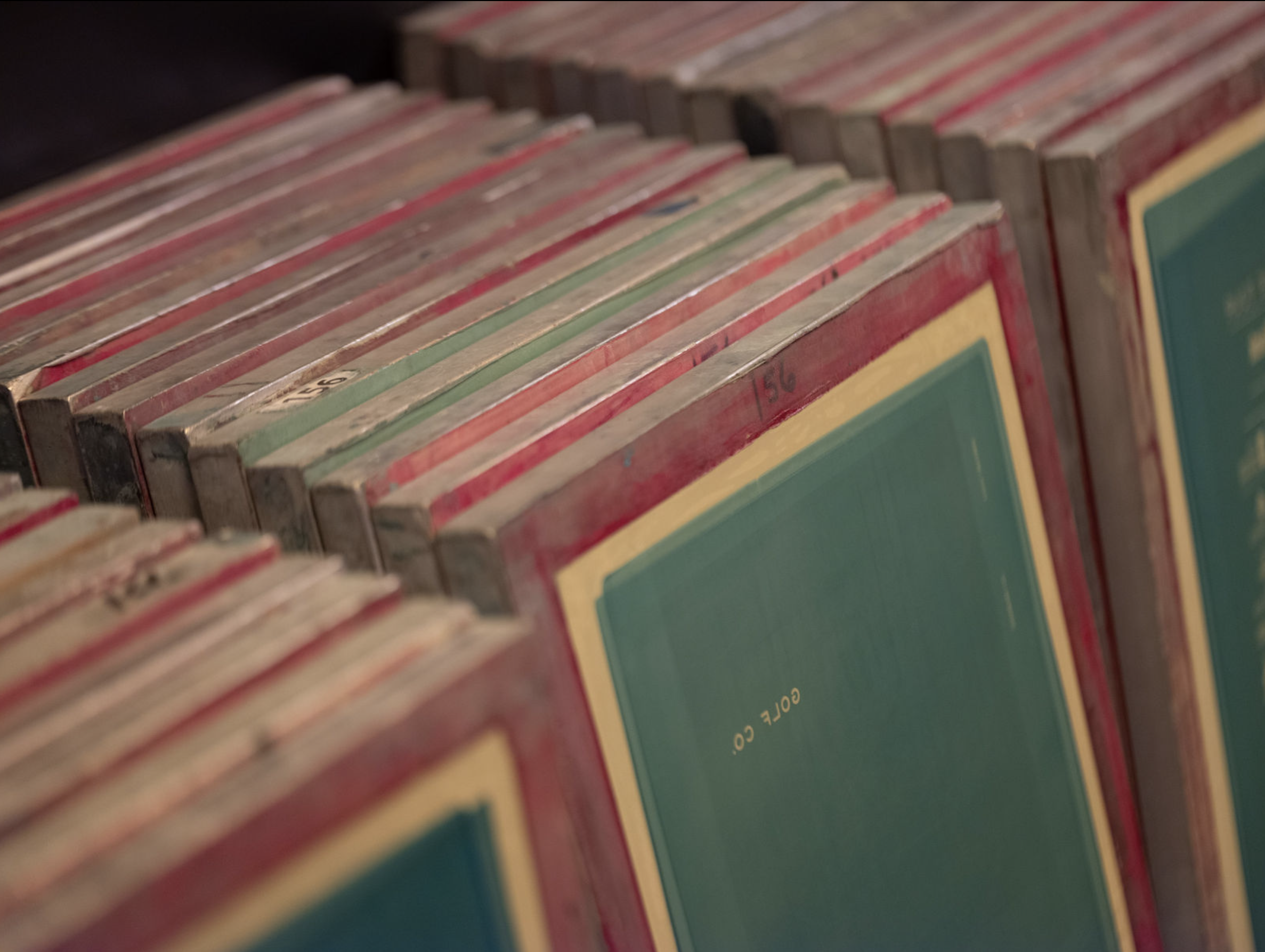 Organized screen-printing frames lined up and ready for production.